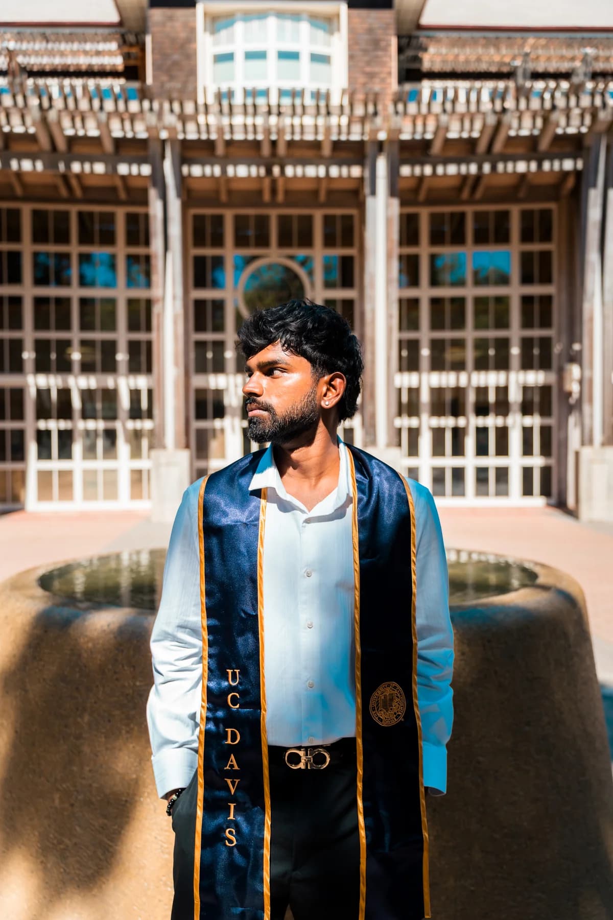 Sanjay Manivasagam wearing his UC Davis graduation stole outdoors